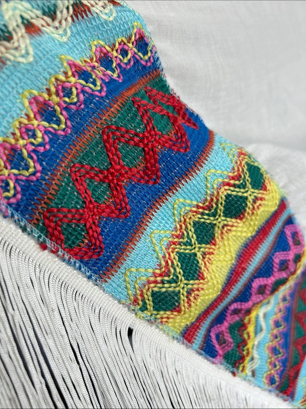 World Market white fringe scarf with red blue yellow green stitching